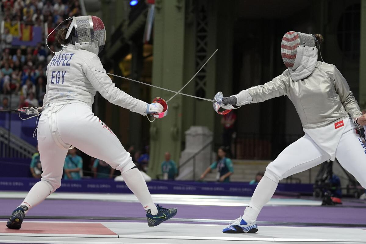 Egypt's Nada Hafez, left, competes against the United States' Elizabeth Tartakovsky in fencing.