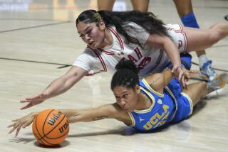 Utah's Alissa Pill, left, and UCLA guard Camryn Brown, right, battle for a loose ball.