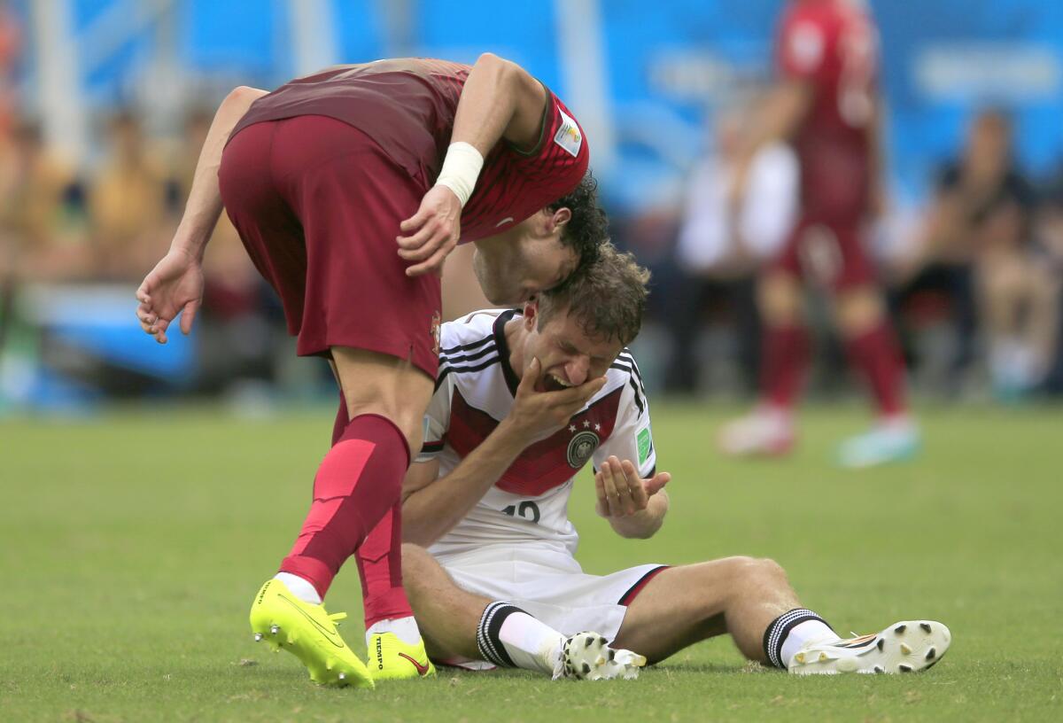 Portugal's Pepe, left, puts his head on Germany's Thomas Mueller during a Group G World Cup match Monday morning.