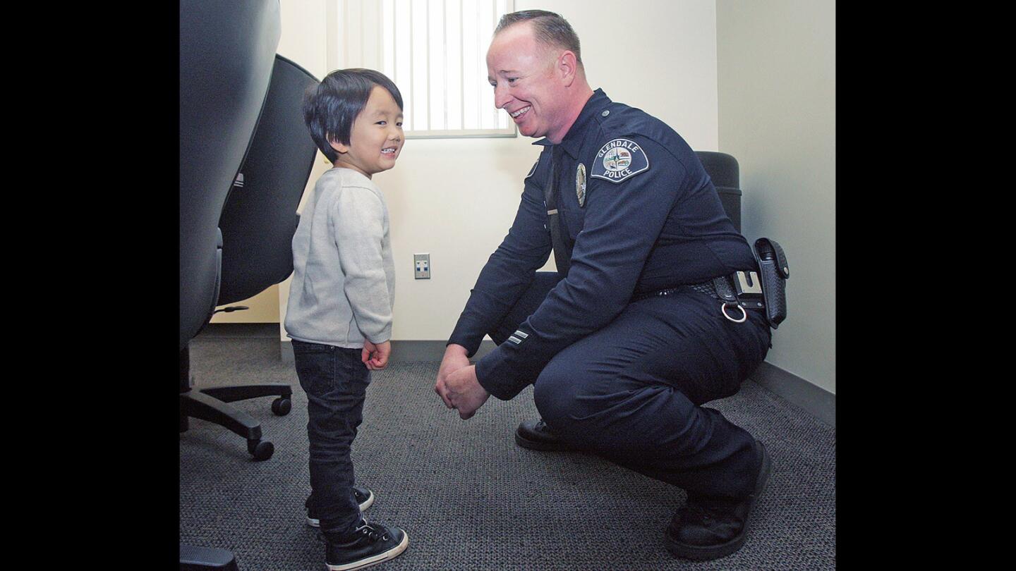 Clayton Cha, 3, starts to get a little mischievous with Glendale police officer James Colvin at the Glendale Police Department on Thursday, Jan. 22, 2016. Last April, Colvin was the first on the scene to treat then 2-year-old Clayton, who had fallen on his head from 22-feet onto concrete.