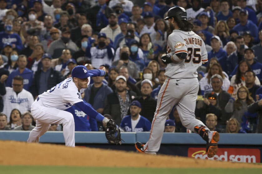 Dodgers first baseman Cody Bellinger catches the ball to force out Giants shortstop Brandon Crawford.