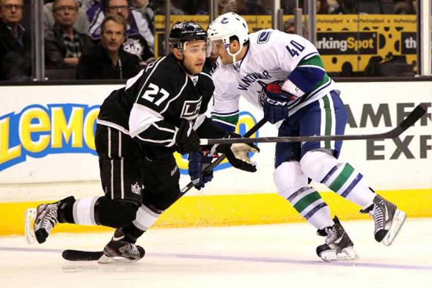 Kings defenseman Alec Martinez turns to defend Canucks winger Maxim Lapierre during a game earlier this season.