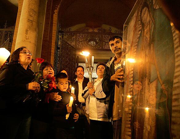 People sing and pray in front of St. Andrews Church in Pasadena after the torch honoring the Virgin of Guadalupe passes through. The relay began in Mexico City and made its way throughout Southern California.
