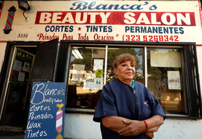 Blanca Rodriguez stands in front of her beauty salon.