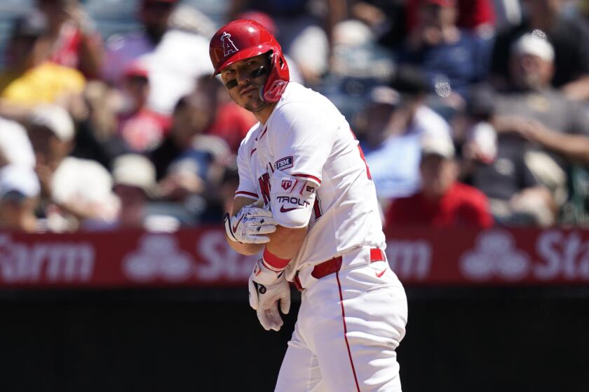 Los Angeles Angels designated hitter Mike Trout, left, tosses his bat after drawing a walk.