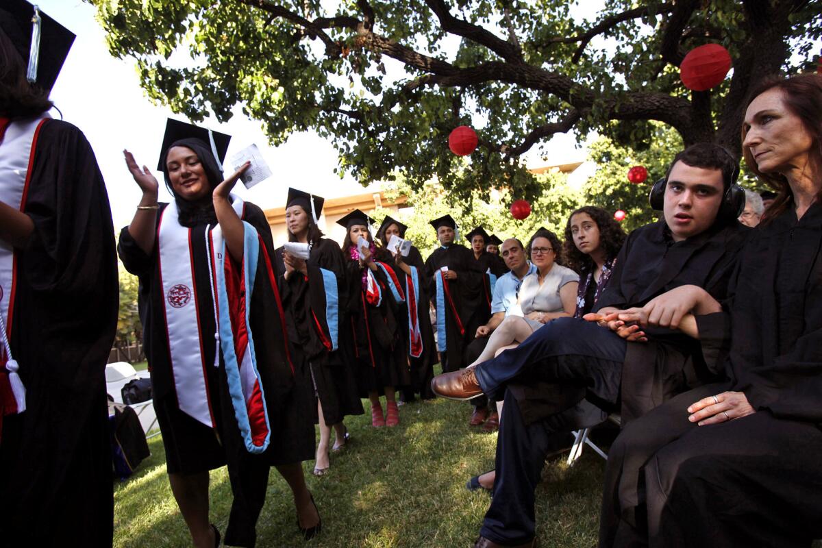 Ido Kedar sits with former teacher and friend Adrienne Johnston, right, along with his family after speaking at Cal State Northridge.