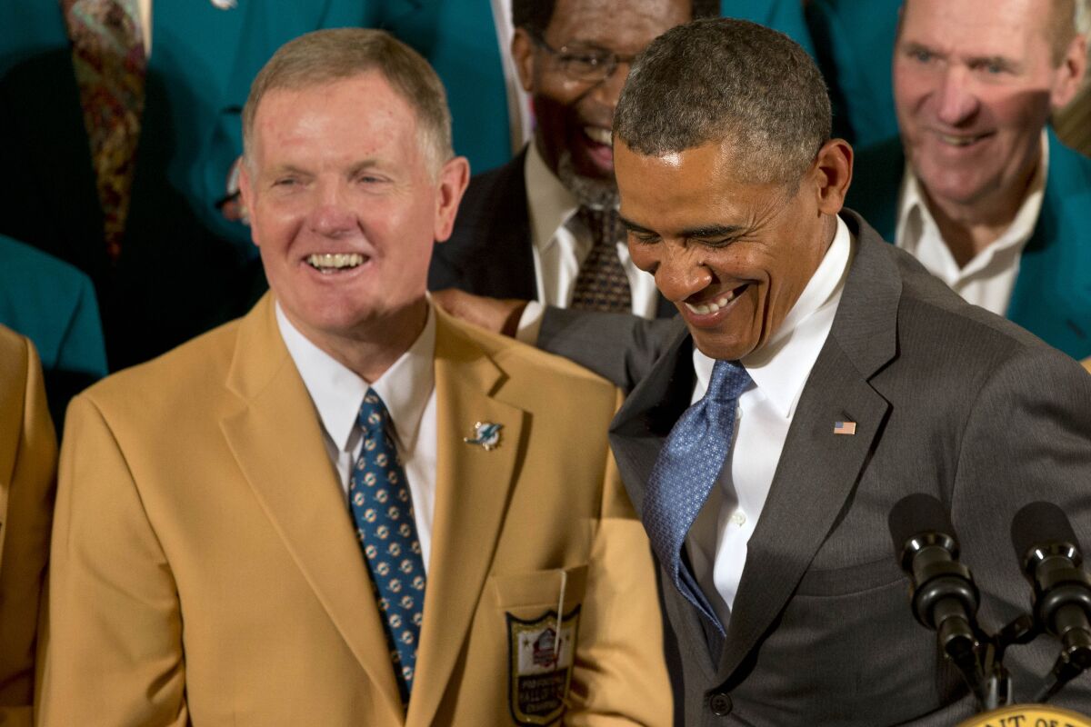 Former Miami Dolphin football quarterback Bob Griese, left, laughs with President Barack Obama on Aug. 20, 2013