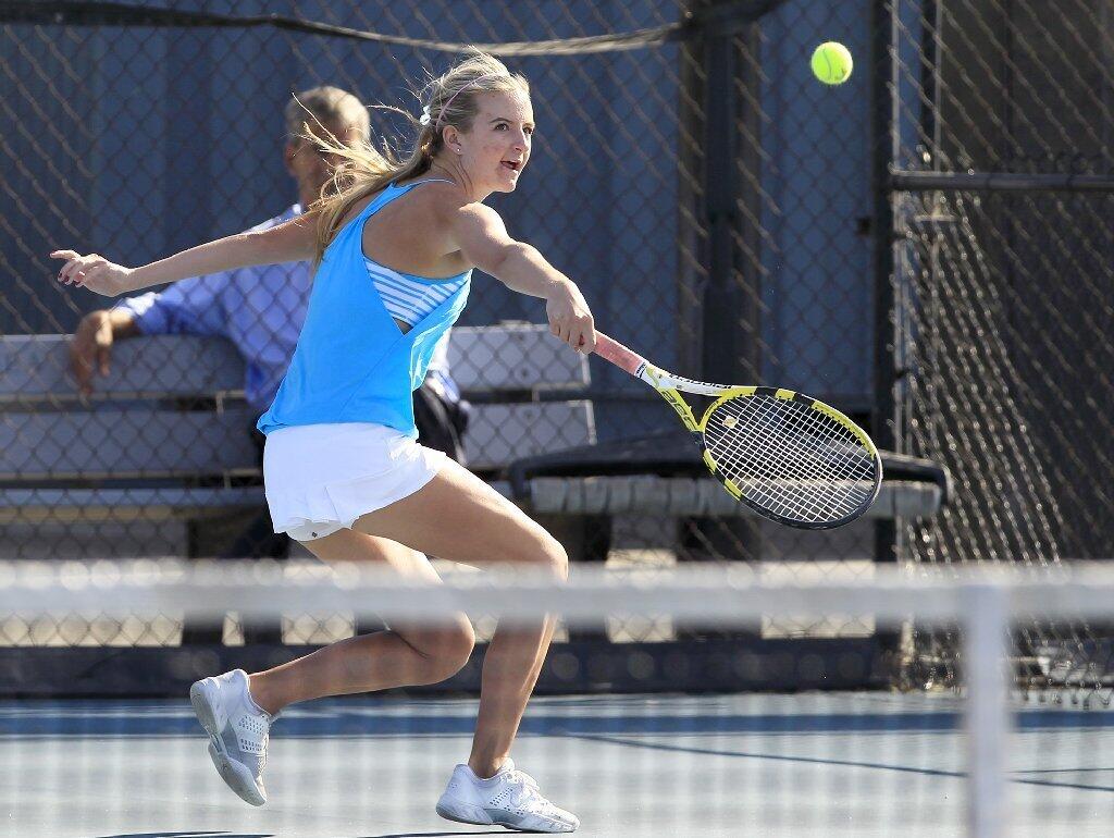 Corona del Mar High's Kenzie Purciful backhands the ball during a doubles match against Peninsula on Wednesday.