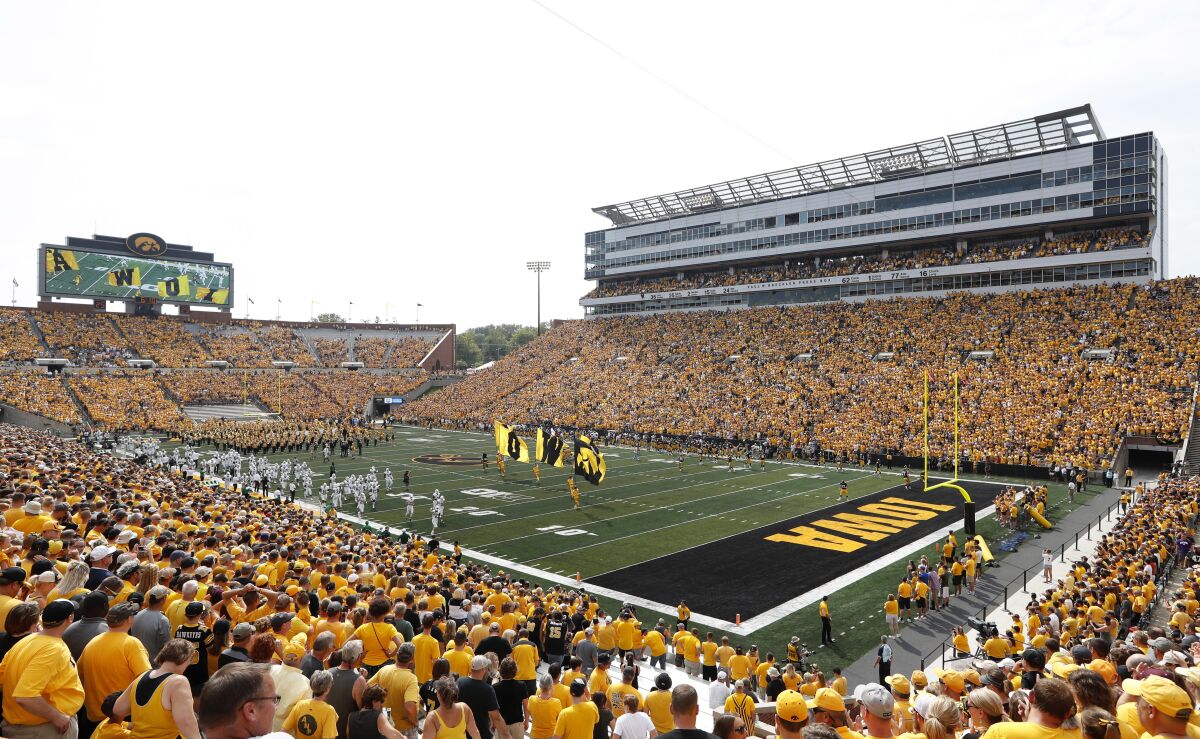 FILE - Fans cheer before an NCAA college football game between Iowa and North Texas at Kinnick Stadium in Iowa City, Iowa, in this Saturday, Sept. 16, 2017, file photo. Iowa will expand alcohol sales at Kinnick Stadium and its other athletic venues as part of a pilot program beginning this fall, the athletic department announced Thursday, June 10, 2021. (AP Photo/Charlie Neibergall, File)