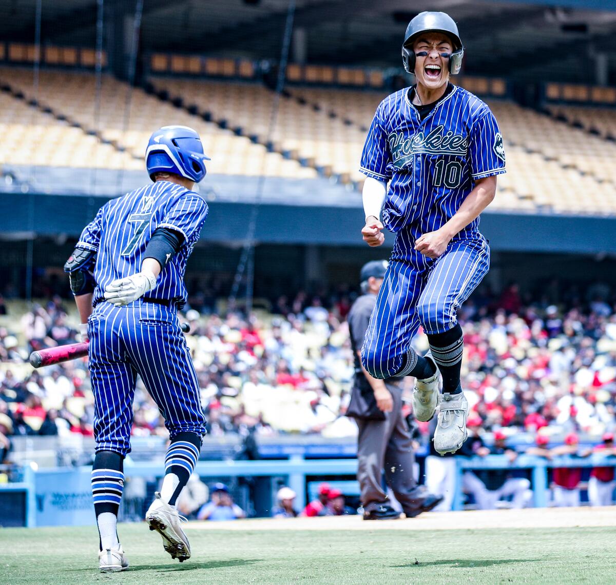 North Hollywood High's Nick Park, right, leaps for joy in the eighth inning at Dodger Stadium. 