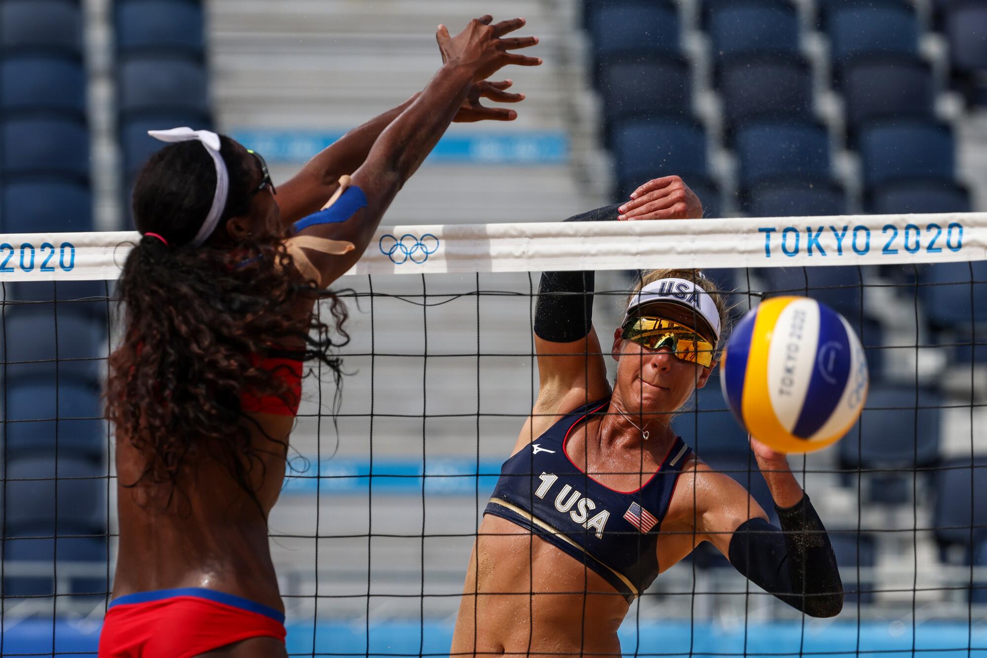 Two women leap at the net.