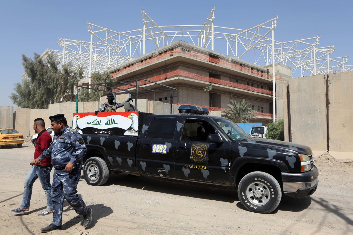 Iraqi security forces guard the entrance to a sports complex being built by a Turkish company in the Baghdad district of Sadr City. Masked men kidnapped 18 Turkish workers employed at the site on Sept. 2.