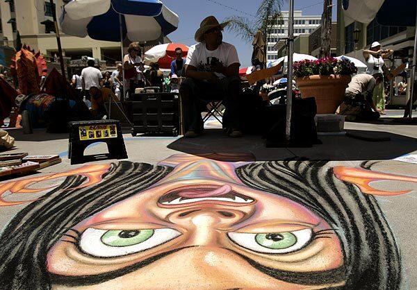 Kevin Ramirez, a professional artist, with his chalk mural, "Cuteness Can Gag a Vampire" during the 18th annual Pasadena Chalk Festival in Pasadena. This is his eighth year participating. See full story