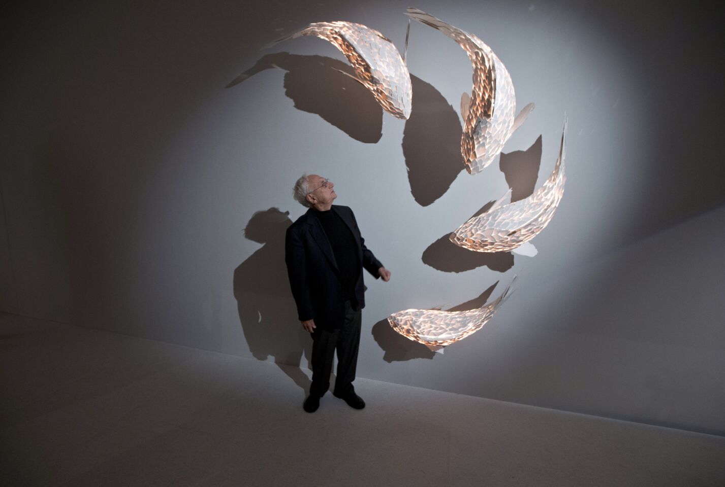 Frank Gehry, who has recently been announced as the architect to take on the redevelopment of Battersea Power Station, stands next to his fish lamps at the opening of his exhibition at the Gagosian Mayfair gallery, in central London.