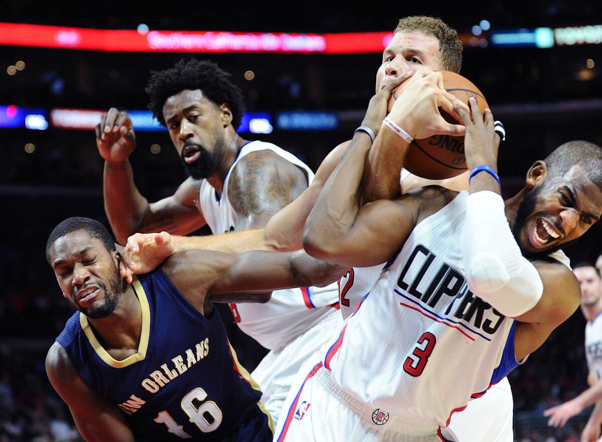 Clippers point guard Chris Paul, right, battles for a rebound along with teammates Blake Griffin and DeAndre Jordan as well as Pelicans guard Toney Douglas in the second half Friday night.