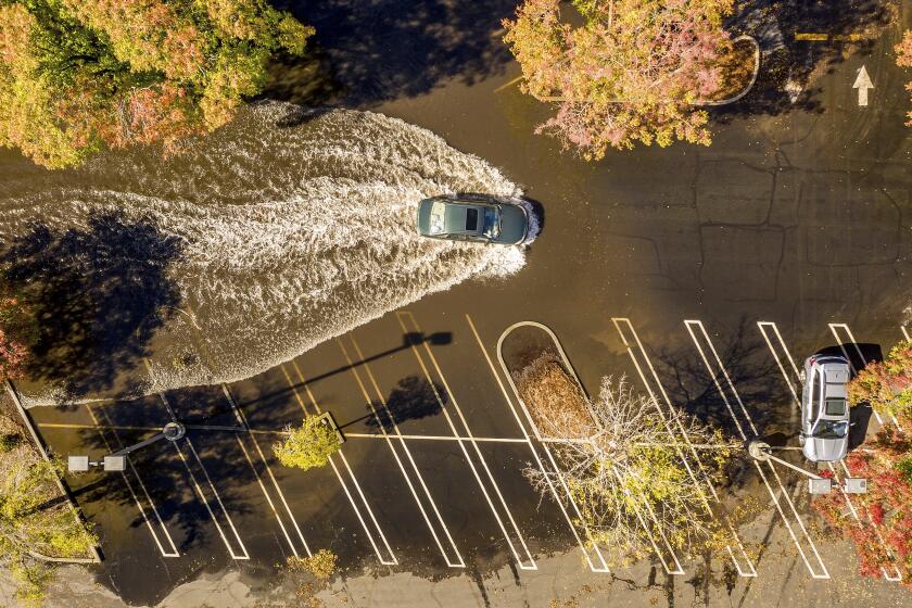 A car crosses a flooded parking lot in Oroville, Calif., on Monday, Oct. 25, 2021. 