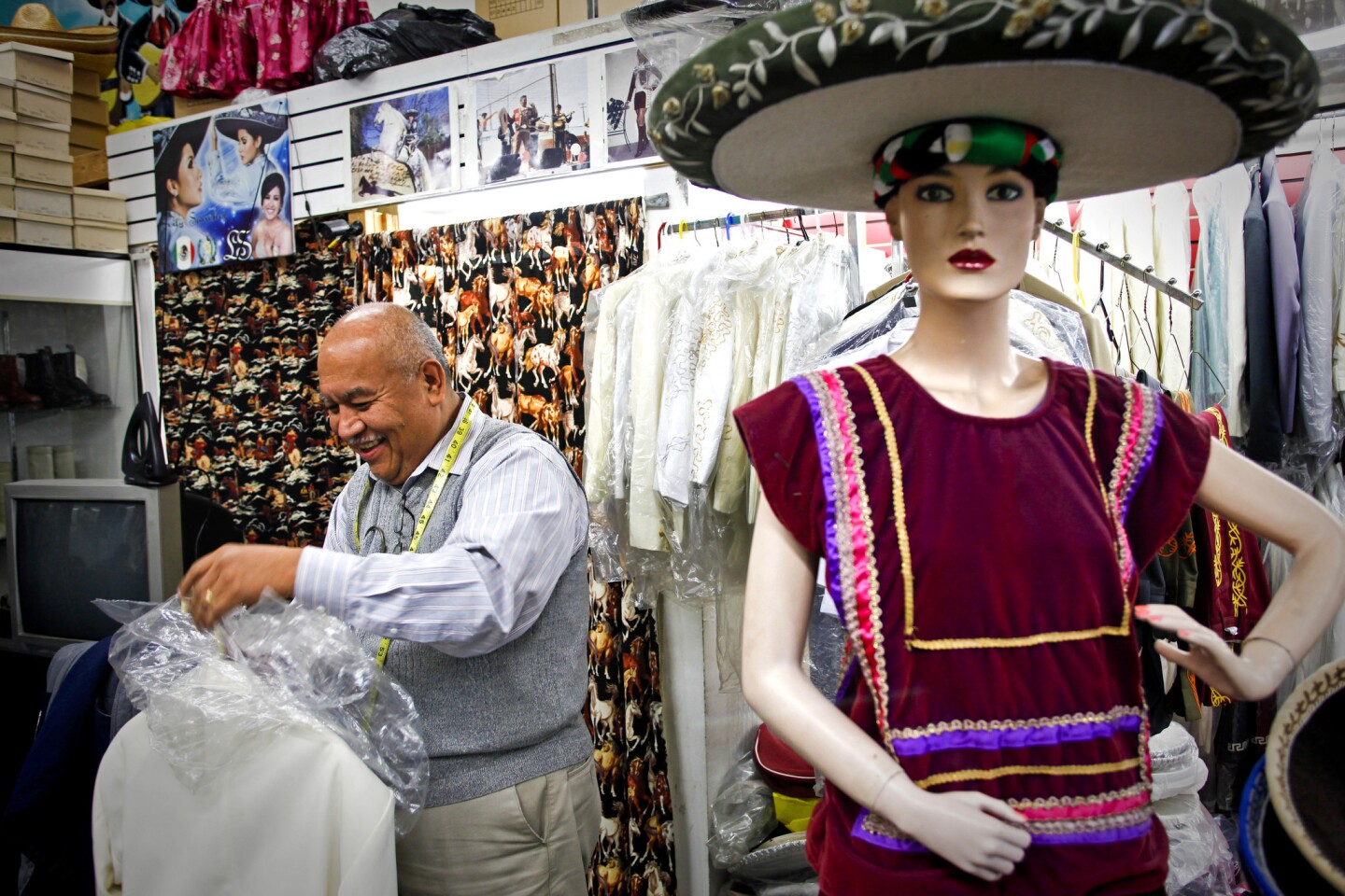 Jorge Tello carefully wraps a finished mariachi suit at his store in Boyle Heights. Tello has been a tailor for the mariachi of Los Angeles and beyond since 1984.
