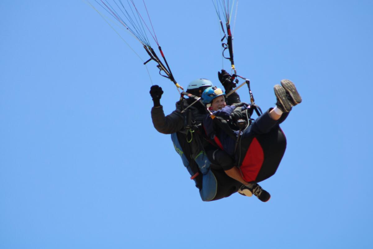 Wanda Parrent, 90, paraglides over friends and family for her birthday.