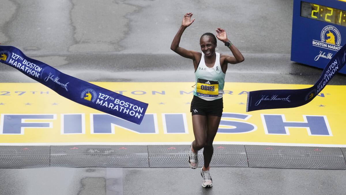 Hellen Obiri, of Kenya, breaks the tape at the finish line to win the women's division of the Boston Marathon