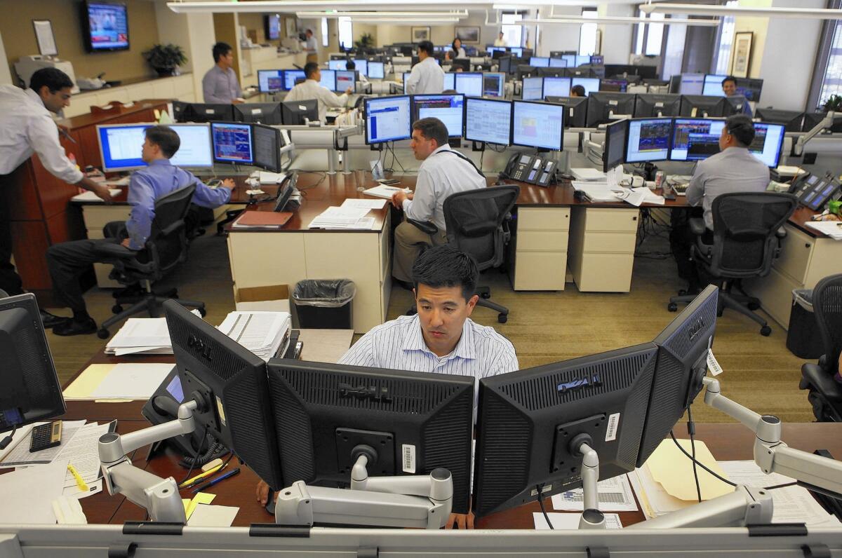 Patrick Ahn works on the trading floor at TCW Inc.'s office in Los Angeles. On Monday, traders with the company monitored news reports, looking for any scrap of intelligence from Greece or other global markets.
