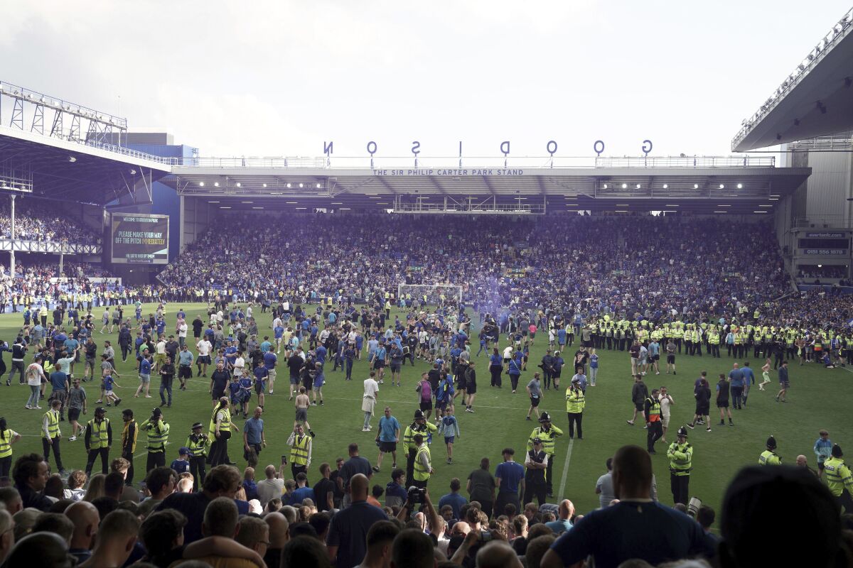 Los hinchas de Everton invaden la cancha luego que el club aseguró la permanencia en la Liga Premier, el domingo 28 de mayo de 2023, en Liverpool, Inglaterra. (Peter Byrne/PA vía AP)