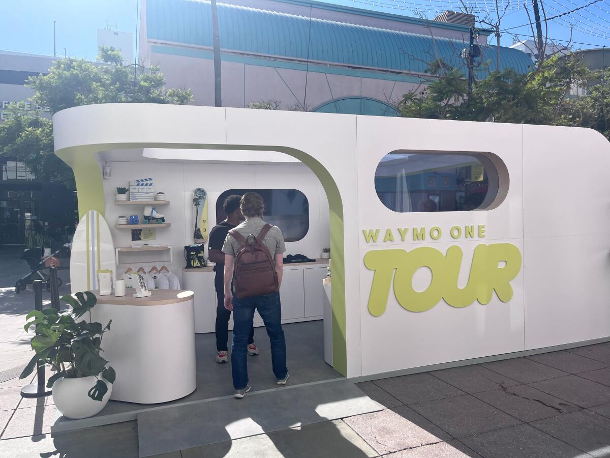 A Waymo booth promoting its driverless taxis