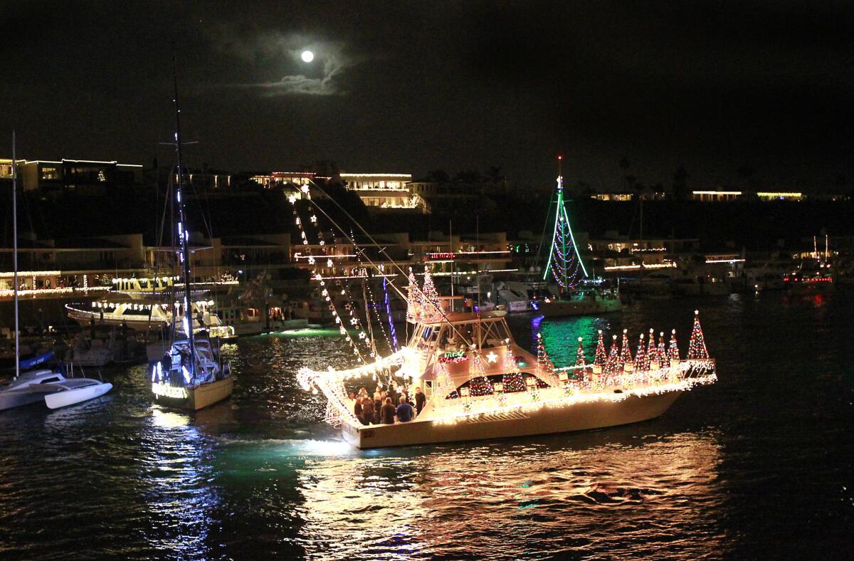 The Quitena makes a turn near the Balboa Bridge under the full moon while participating in the "Rockin Around the Christmas Tree" 105th annual Newport Beach Christmas Boat Parade on Wednesday.