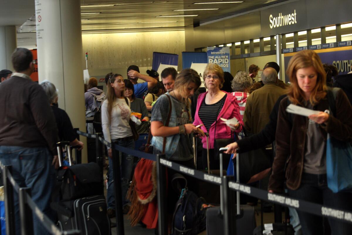 Thanksgiving travelers wait to check in at Terminal 1 at Los Angeles International Airport on Nov. 23, 2011. The airport expects to set a new passenger record during this year's Thanksgiving travel period.