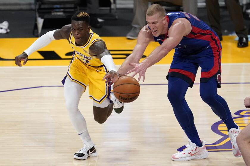 Los Angeles Lakers guard Dennis Schroeder, left, works for a loose ball against Detroit Pistons center Mason Plumlee during the second half of an NBA basketball game Saturday, Feb. 6, 2021, in Los Angeles. (AP Photo/Marcio Jose Sanchez)