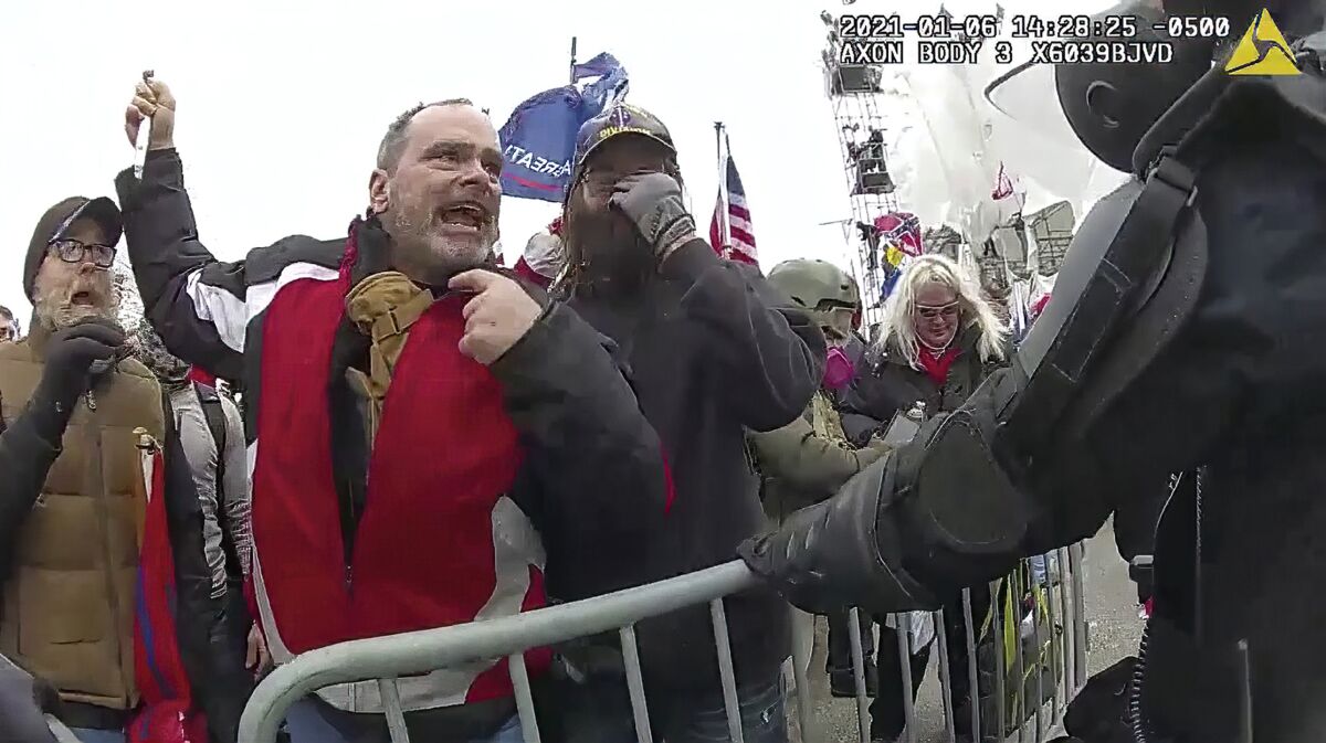 This still frame from Metropolitan Police Department body worn camera video shows Thomas Webster, in red jacket, at a barricade line at on the west front of the U.S. Capitol on Jan. 6, 2021, in Washington. More than 800 people across the U.S. have been charged in the Jan. 6 riot at the Capitol that left officers bloodied and sent lawmakers running in fear, and federal authorities continue to make new arrests practically every week (Metropolitan Police Department via AP)