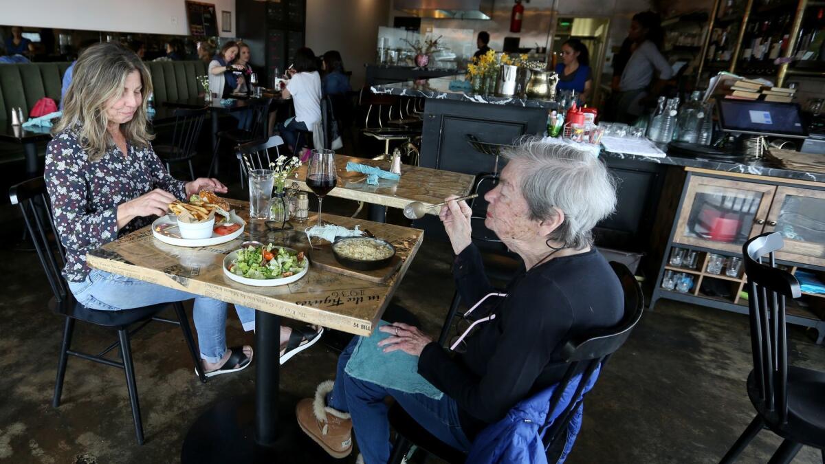 The New Deal owner Kerry Krull, left, enjoys a fried chicken sandwich while her mother has the Mac & Cheese and a salad.