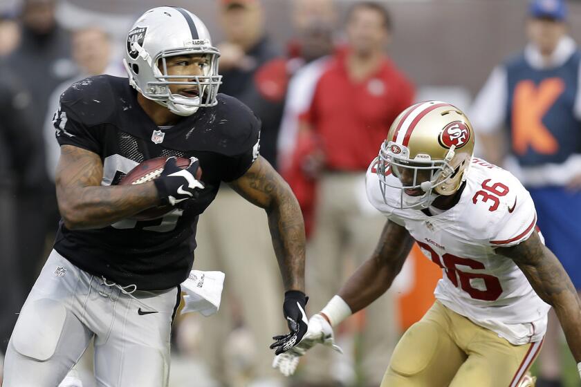 Oakland Raiders tight end Mychal Rivera, left, runs against San Francisco 49ers defensive back Dontae Johnson during the second half of the Raiders' 24-13 win Sunday.
