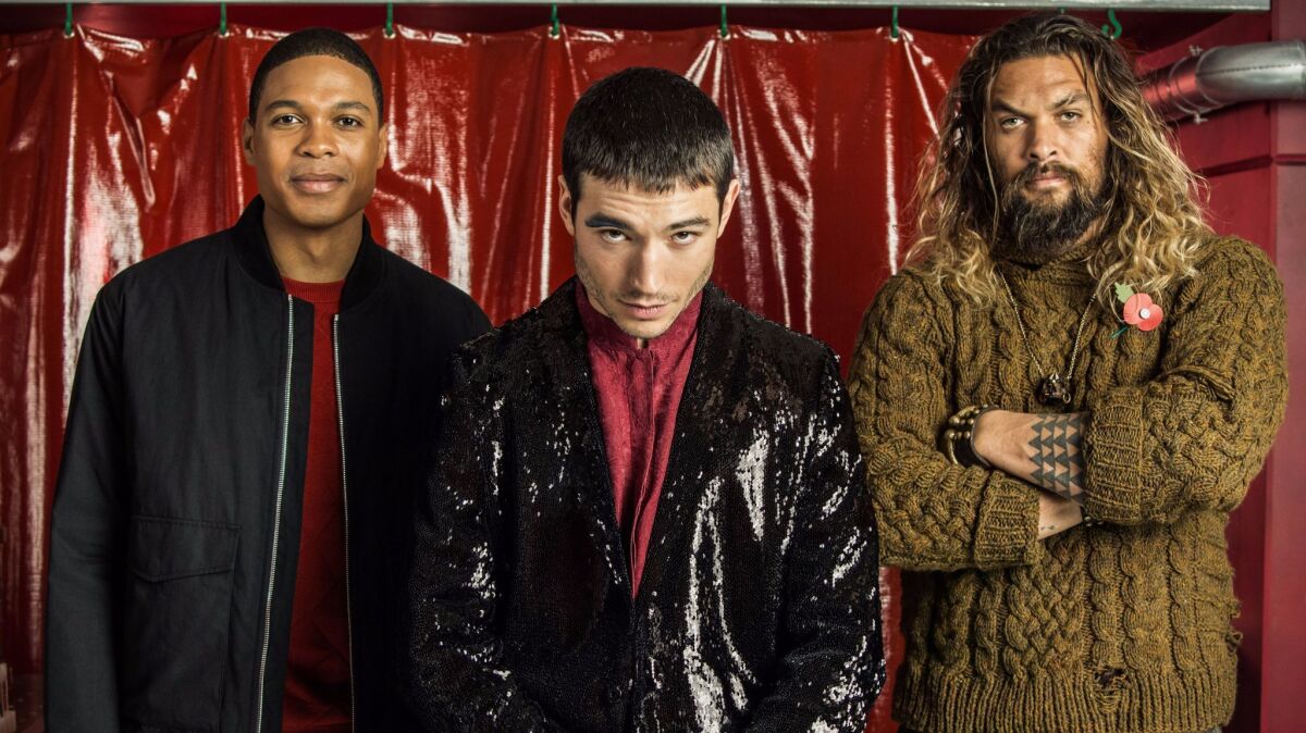 From left: Ray Fisher (Cyborg), Ezra Miller (The Flash), and Jason Momoa (Aquaman) pose for pictures in the Star Labs set at the press day event for the upcoming film "Justice League."