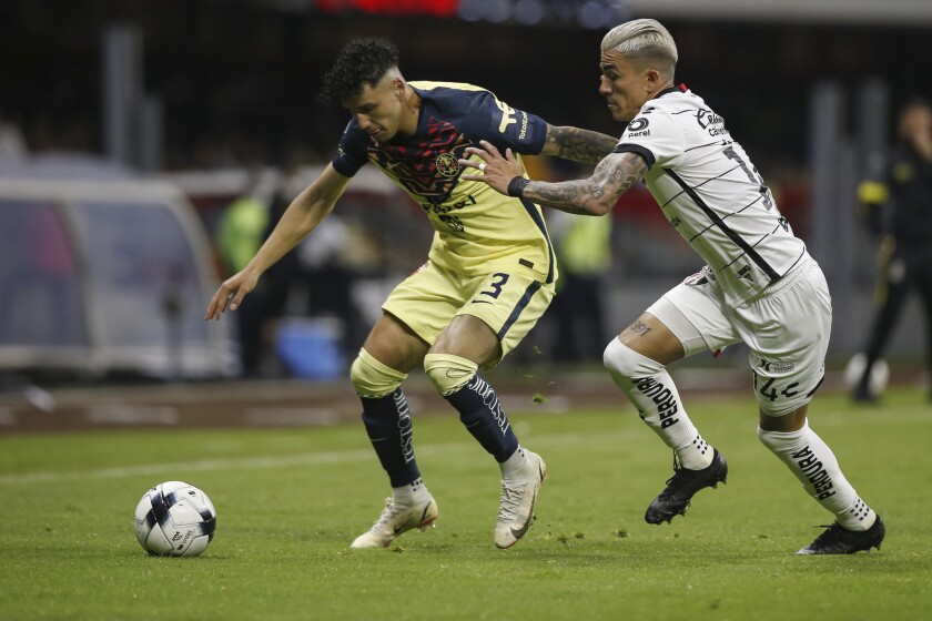 Jorge Sánchez, del América, disputa un balón ante Luis Reyes, del Atlas, en un partido de la Liga MX, disputado el sábado 22 de enero de 2022, en el Estadio Azteca (AP Foto/Ginnette Riquelme)