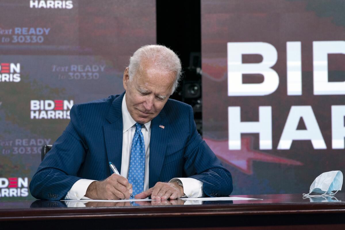 Democratic presidential candidate Joe Biden signs a nomination document