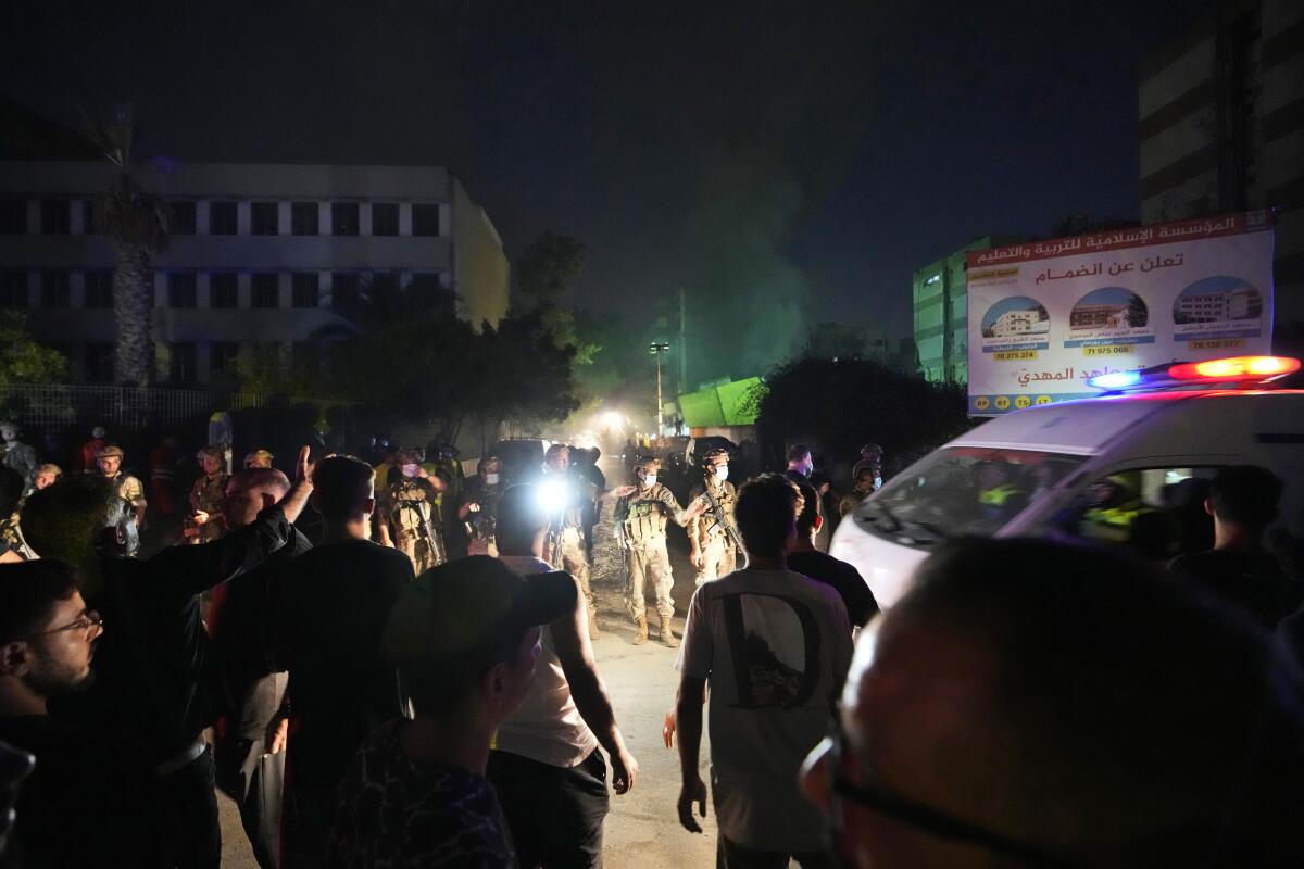 Rescuers arrive near the site of an Israeli airstrike in Beirut's southern suburbs at night.