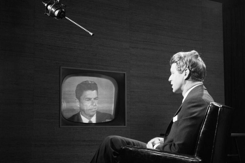 (Original Caption) Syracuse, NY:New York Senator Robert F. Kennedy (right) exchanges views with California Governor Ronald Reagan during Television news program on CBS-TV May 15th. Kennedy here and Reagan in Sacramento, the program was also viewed in Londodn via Early Bird Satellite. British youths in London submitted questions to Kennedy and Reagan during the hour-long period. 5/15/1967