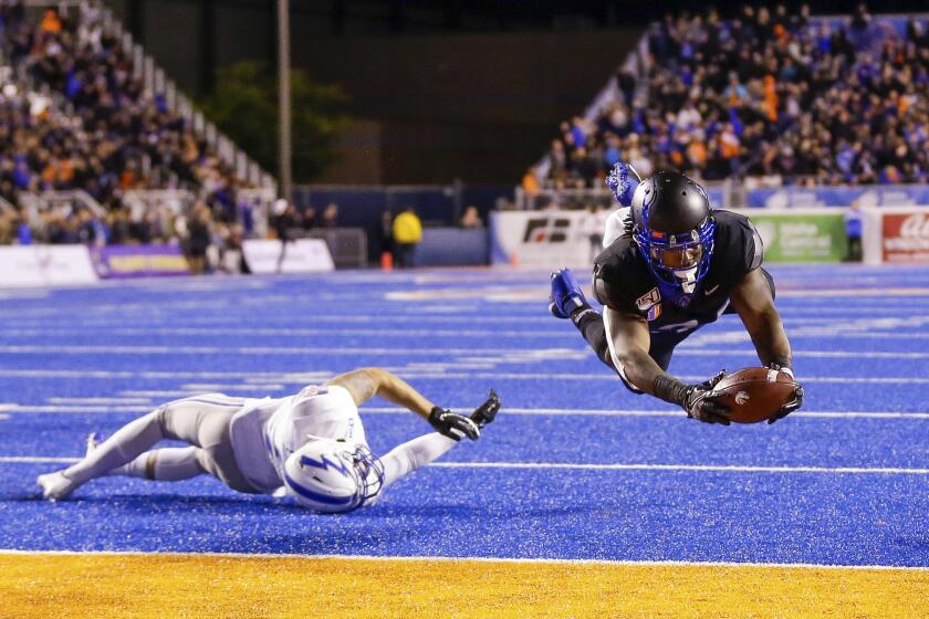 Boise State running back Robert Mahone (34) dives into the end zone for a touchdown after breaking the tackle attempt by Air Force defensive back Jeremy Fejedelem (2) during the second half of an NCAA college football game Friday, Sept. 20, 2019, in Boise, Idaho. Boise State won 30-19. (AP Photo/Steve Conner)