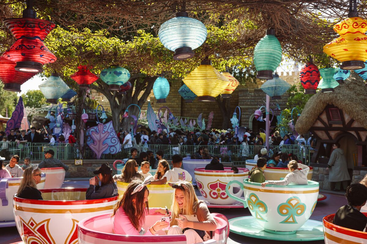 People riding the spinning Teacups ride at Disneyland.