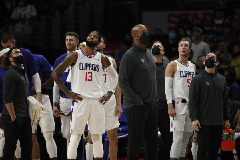 LOS ANGELES, CA - NOVEMBER 21, 2021: Clippers Paul George looks at the video board with other players and coaches to see if the foul called against Terance Mann will be overturned in the second half at Staples Center on November 21, 20201 in Los Angeles, California. The original call charged Mann with a foul on Mavericks Jalen Brunson, but it was overturned after review.(Gina Ferazzi / Los Angeles Times)