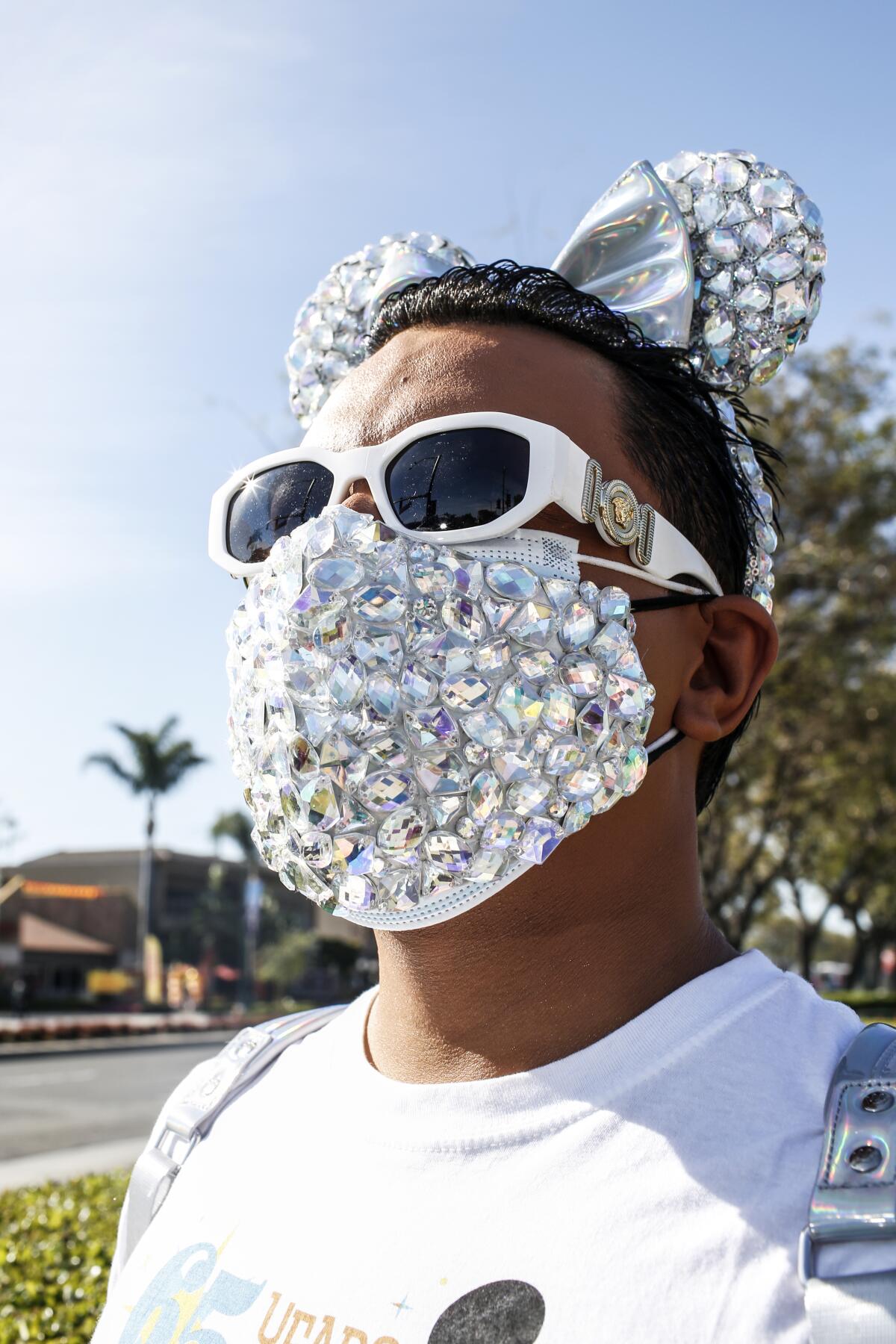 A man in bejeweled mask and mouse ears