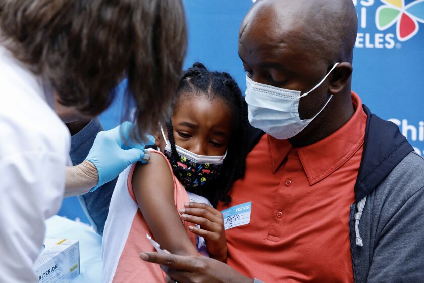 LOS ANGELES, CA NOVEMBER 3, 2021 - Five-year-old Alahna Alleyne is comforted by her Father Samuel Alleyne after she received the children's dose of the Pfizer Covid vaccine from RN Susan Santner at Children's Hospital Los Angeles Wednesday morning, Nov. 3, 2021. (Al Seib / Los Angeles Times)