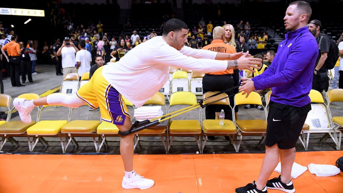 Guard Lonzo Ball, working out with a trainer before a recent exhibition game, is ready to play for the Lakers against Golden State on Wednesday in Las Vegas.