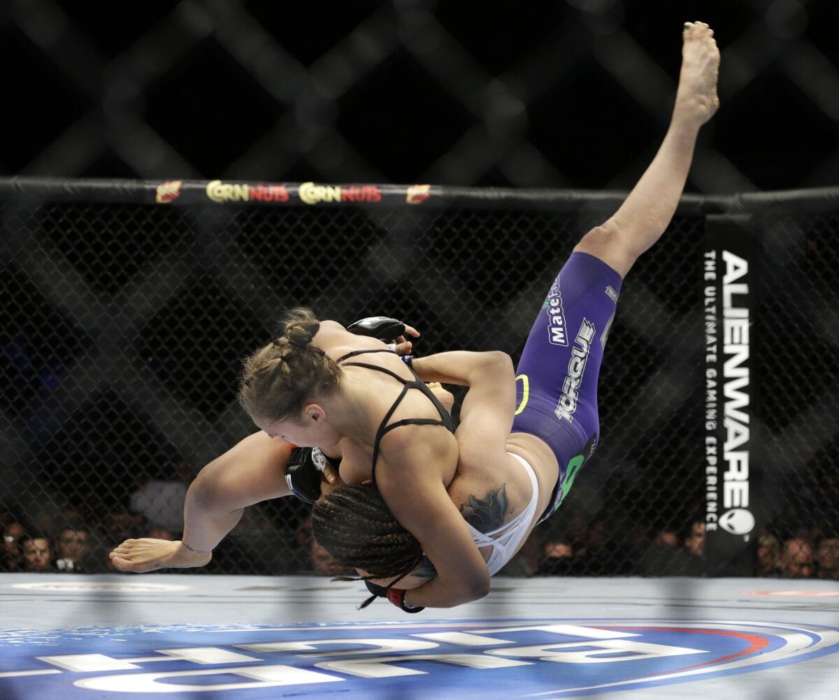 Ronda Rousey uses a judo throw to take down Alexis Davis during their UFC fight Saturday in Las Vegas.