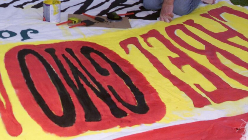 Activists paint a sign calling for the labeling of GMOs.