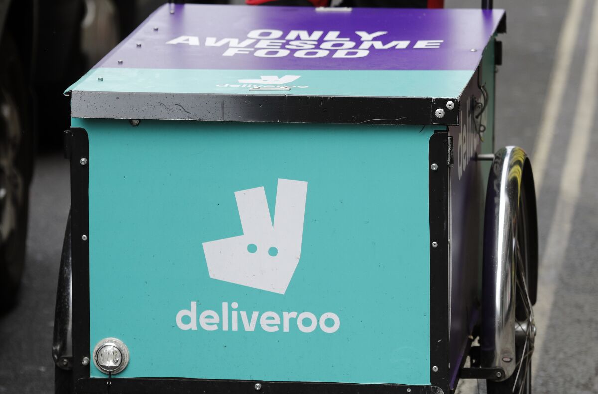 FILE - This Tuesday, July 11, 2017 file photo, shows a deliveroo logo on a bicycle in London. Pizzerias, ride-hailing apps and food delivery services are backing Britain’s COVID-19 vaccination drive, offering discounts and even free slices of pizza to persuade young people to roll up their sleeves and get the shot. The program was announced Sunday Aug. 1, 2021 by the Department of Health and Social Care. (AP Photo/Frank Augstein, File)