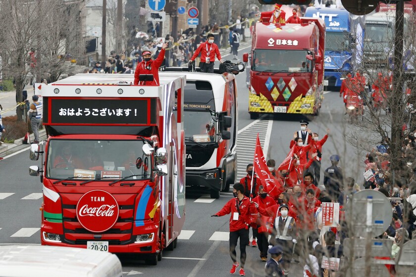 FILE - In this March 28, 2021, file photo, Olympic sponsors' vehicles parade ahead of torch relay in Ashikaga, Tochigi prefecture, north of Tokyo. The Olympic corporate sponsorship program has been a key part of the Olympic experience since it began in 1985. But all that magic from the Olympic sponsorship is being undermined because of the virus. (Shinji Kita/Kyodo News via AP, File)