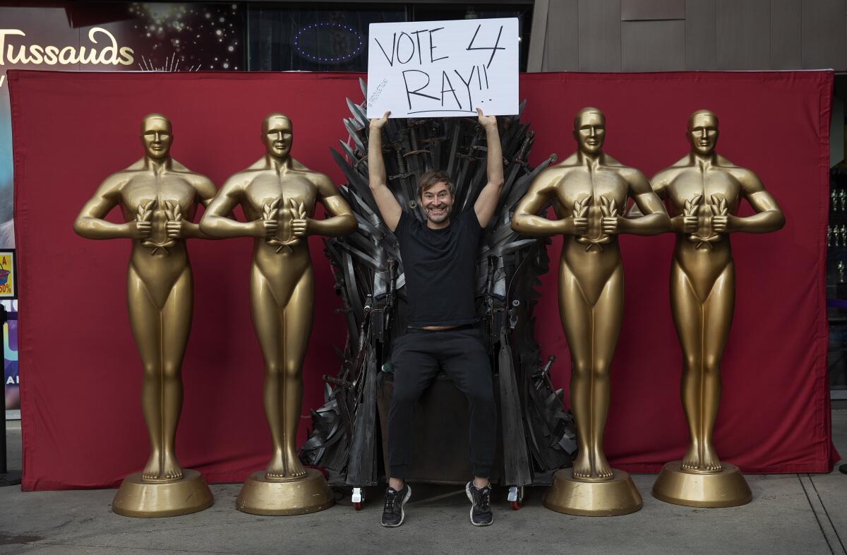 Mark Duplass poses with Oscar statues on Hollywood Boulevard.