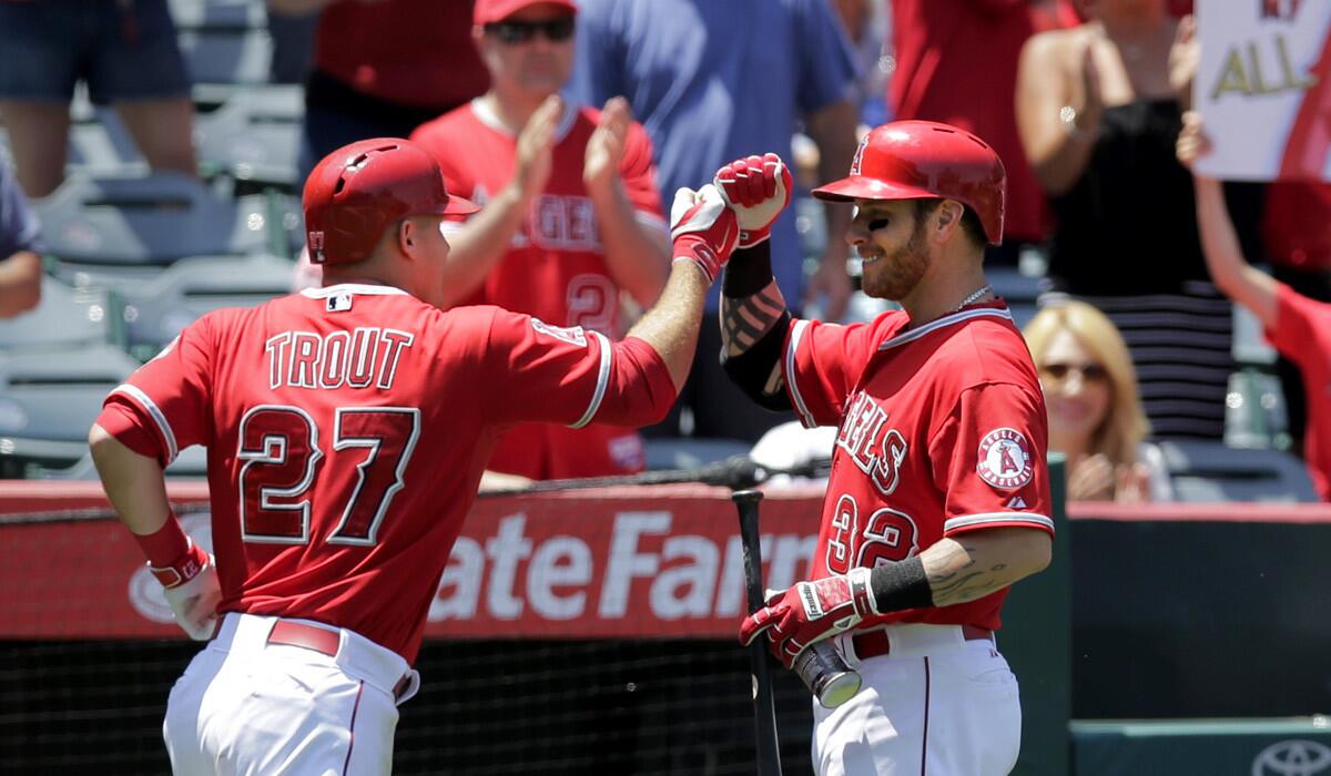 Angels center fielder Mike Trout is congratulated by teammate Josh Hamilton after hitting a home run in the third inning against the Mariners on Sunday afternoon in Anaheim.