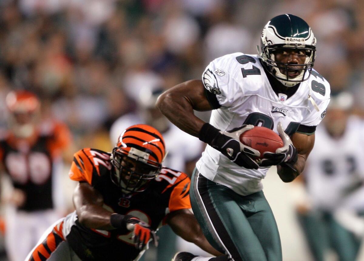 Philadelphia's Terrell Owens runs past Cincinnati's Kim Herring on Aug. 26.